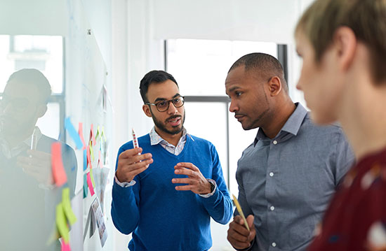 Portrait of a man in a diverse team of creative coworkers in a startup brainstorming strategies - stock photo