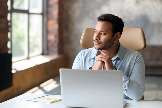 Serious concentrated clever freelancer guy using laptop for searching - stock photo