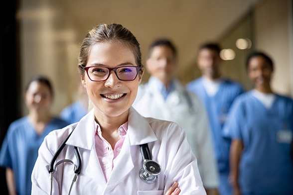 Happy doctor leading a group of healthcare workers at the hospital - stock photo