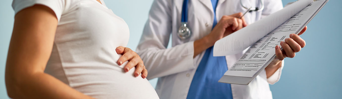 Pregnant female looking at paper with medical prescriptions held by her therapeutist