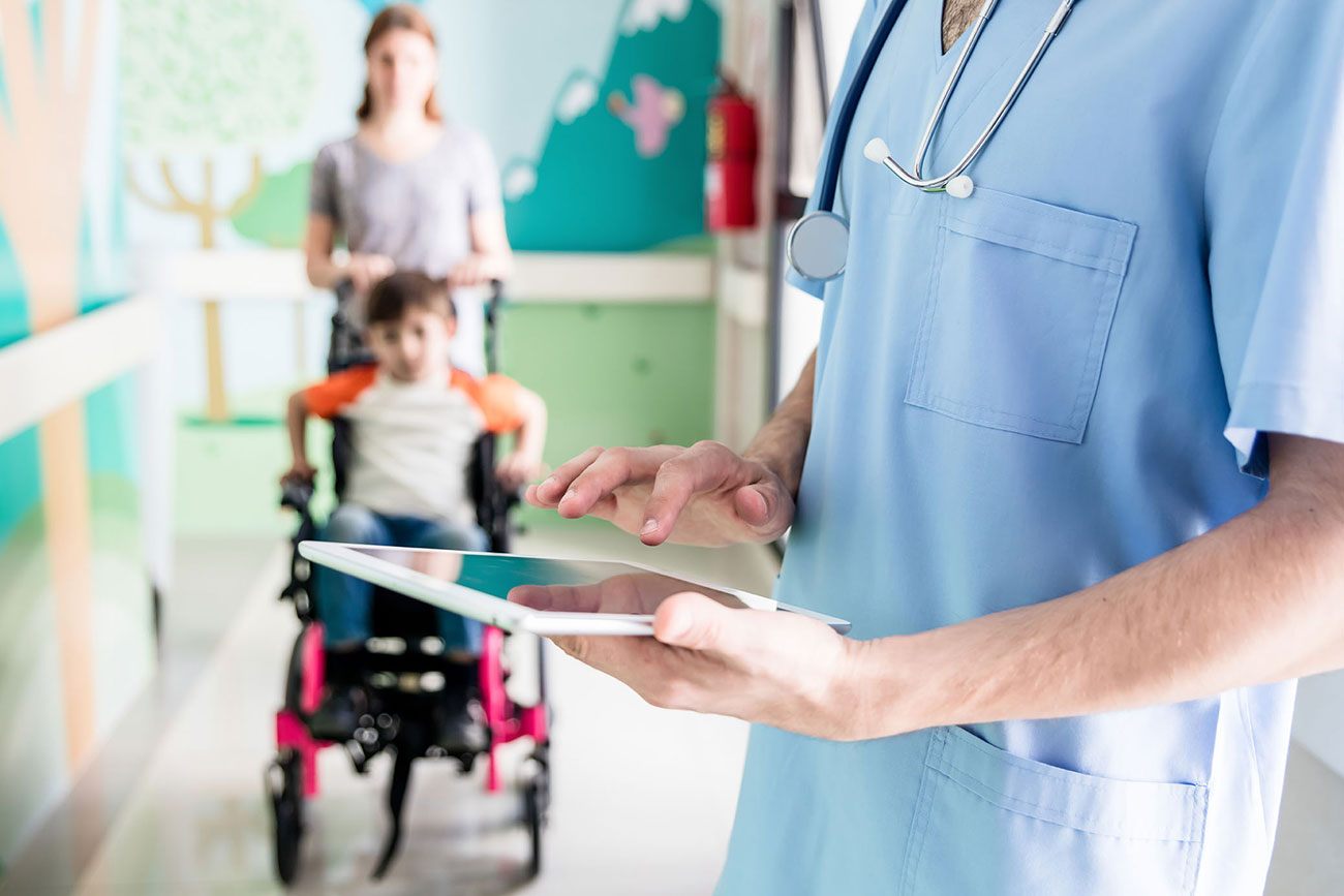 Doctor holding an ipad with a patient in background