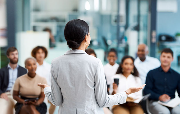 Learning on the job - stock photo Rearview shot of an unrecognizable businesswoman giving a presentation in the office boardroom