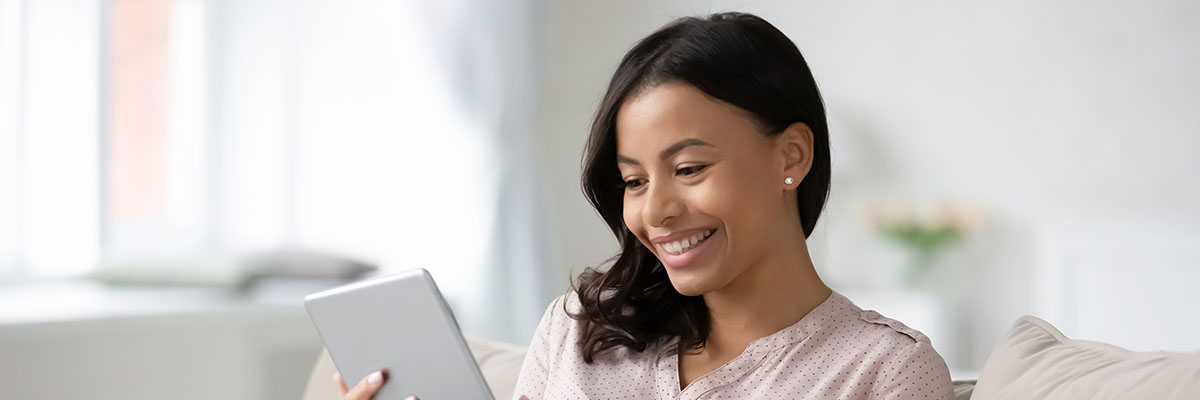 Smiling african American woman busy browsing tablet