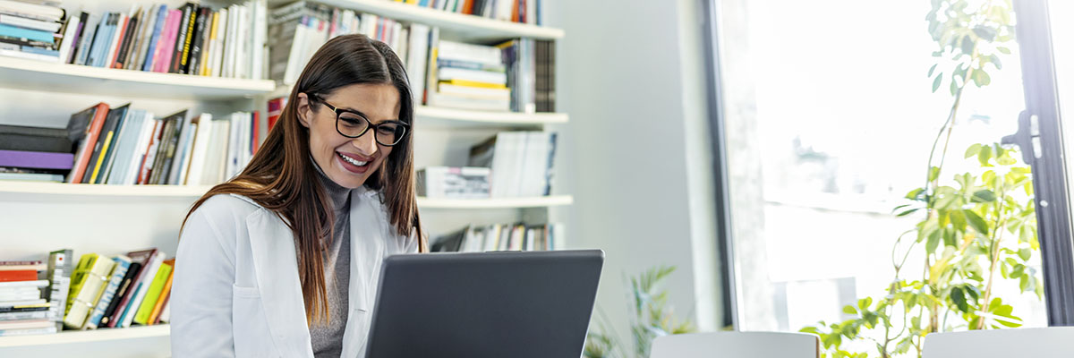 Shot of a female doctor working on medical expertise while sitting at desk in front of laptop.