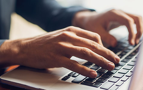 hands using a laptop keyboard