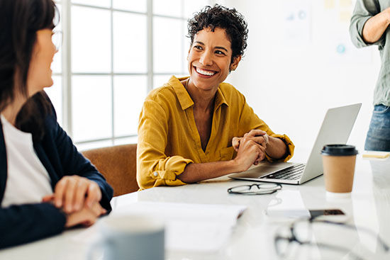 Business woman talking to her colleague during a meeting in a boardroom - stock photo